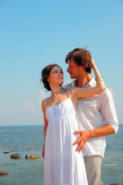 Feliz, joven pareja junto a la orilla del mar — Foto de Stock