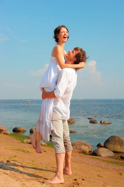 Feliz, joven pareja junto a la orilla del mar — Foto de Stock