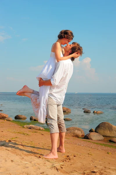Lyckliga par njuter av semester på stranden — Stockfoto