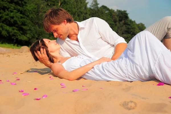 Счастливая пара играет на пляже — стоковое фото