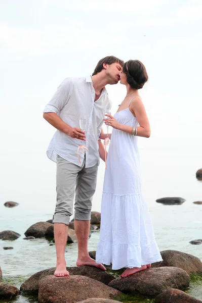 Pareja romántica sosteniendo las manos y besándose en una playa —  Fotos de Stock