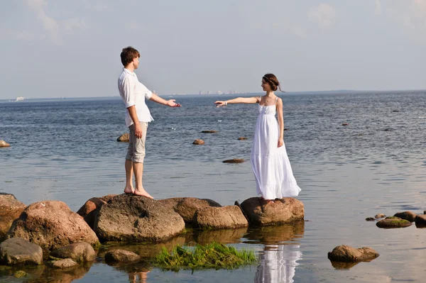 Pareja romántica joven camina en el agua —  Fotos de Stock