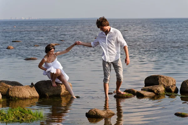 Pareja romántica joven camina en el agua — Foto de Stock