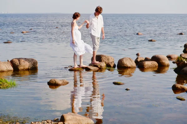 Молодая романтическая пара гуляет по воде — стоковое фото