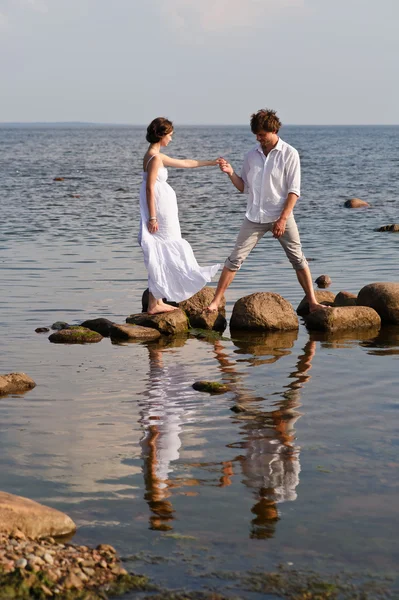 Unga romantiska par går på vatten — Stockfoto