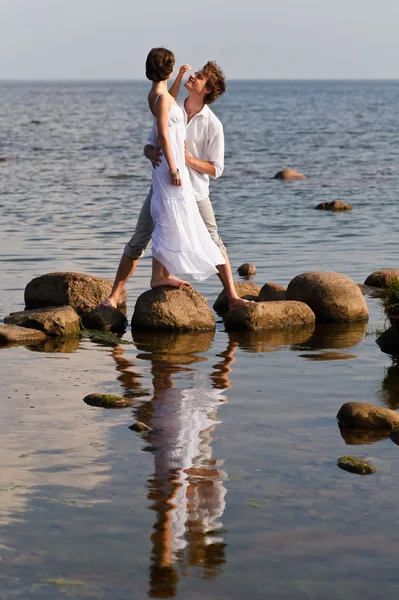 Pareja romántica joven camina en el agua — Foto de Stock