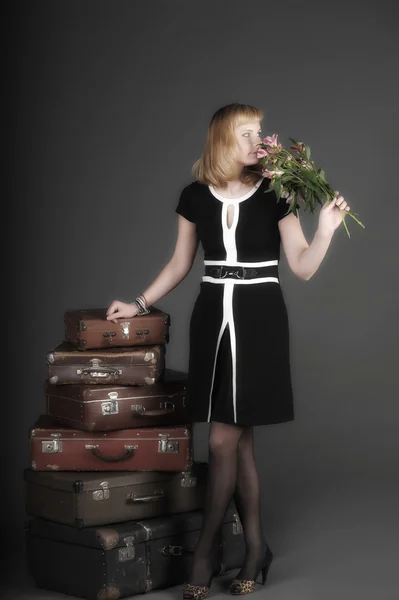 Fiatal nő, és sok régi bőröndök — Stock Fotó