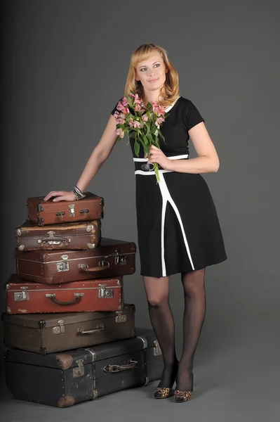 Jonge vrouw en een veel oude koffers — Stockfoto