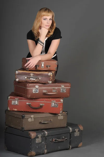 Ung kvinna och en massa gamla resväskor — Stockfoto