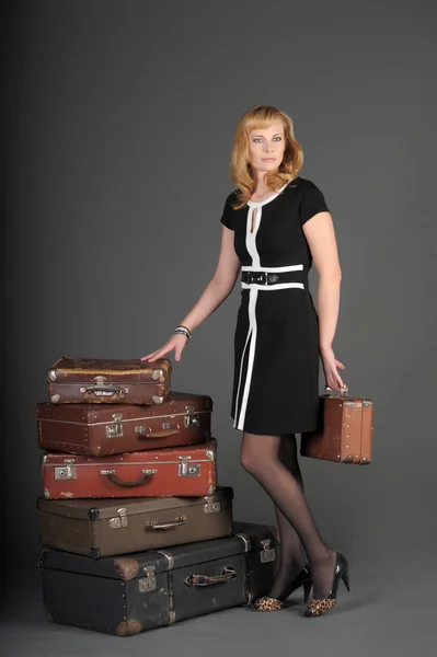 若い女性と多くの古いスーツケース — ストック写真