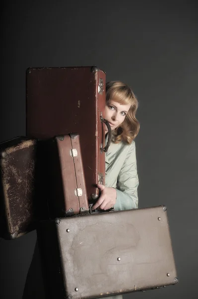 Mujer joven y un montón de maletas viejas —  Fotos de Stock