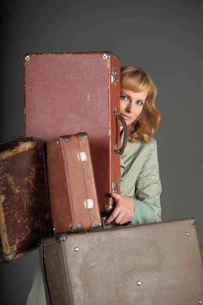 Junge Frau und viele alte Koffer — Stockfoto