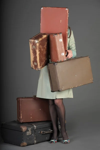 Young woman and a lot of old suitcases — Stock Photo, Image