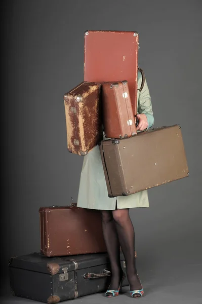 Jonge vrouw en een veel oude koffers — Stockfoto