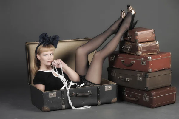 Молодая женщина и много старых чемоданов — стоковое фото