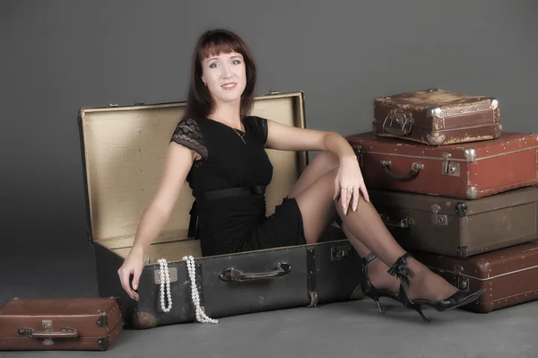 Young woman and a lot of old suitcases — Stock Photo, Image