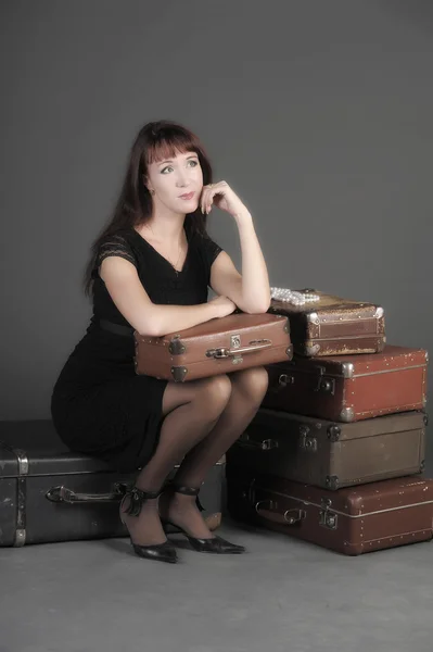 Giovane donna e un sacco di vecchie valigie — Foto Stock