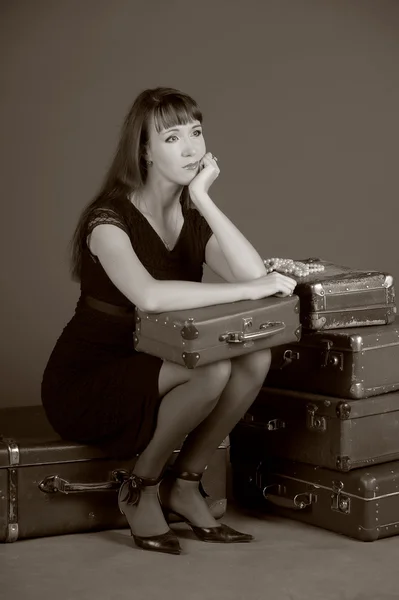 Mujer joven y un montón de maletas viejas — Foto de Stock