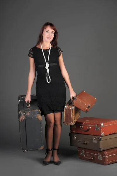 Junge Frau und viele alte Koffer — Stockfoto