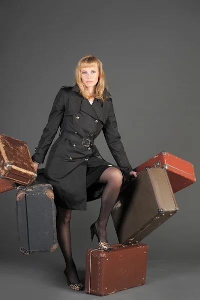 Young woman and a lot of old suitcases — Stock Photo, Image