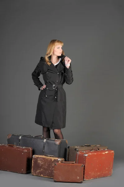 Jeune femme et beaucoup de vieilles valises — Photo