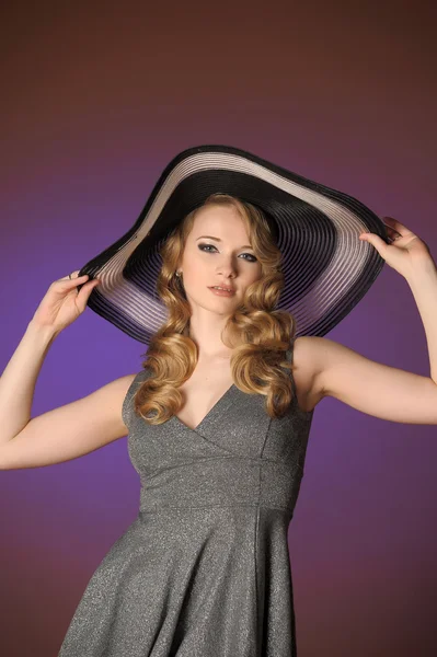 Mode flicka i en stor hatt i studion — Stockfoto