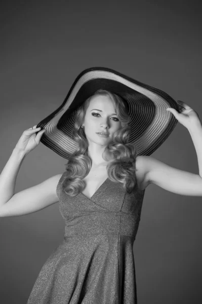 Divat lány egy nagy kalap a stúdióban — Stock Fotó