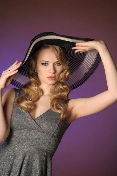 Девушка в большой шляпе в студии — стоковое фото
