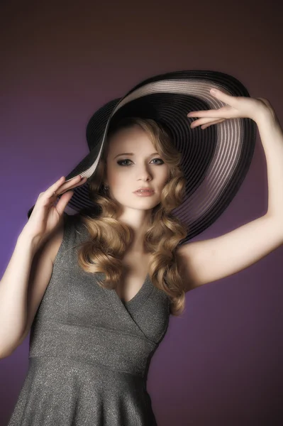 Mode flicka i en stor hatt i studion — Stockfoto