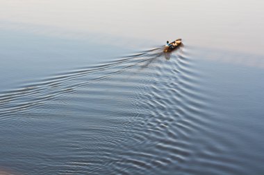 Fishing boat on Moon River in the morning clipart