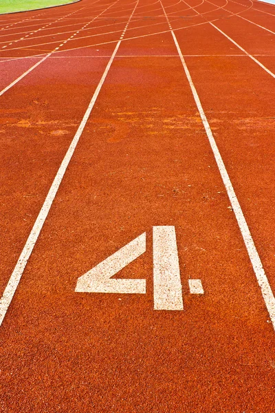 Nummer vier op het begin van een atletiekbaan — Stockfoto