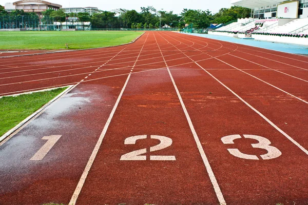 Número uno dos y tres en el inicio de una pista de atletismo — Foto de Stock