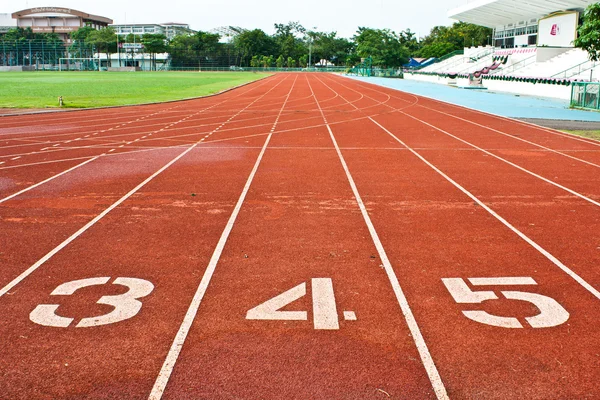 Número tres cuatro y cinco en el inicio de una pista de atletismo — Foto de Stock