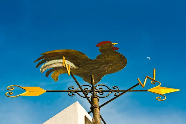 stock image A cockerel wind vane against blue sky