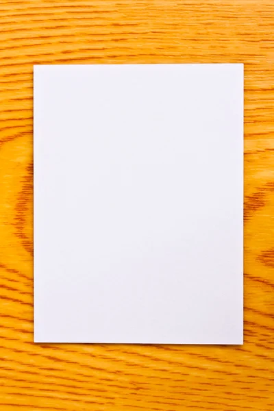 Beyaz kağıt üzerine ahşap masa — Stok fotoğraf