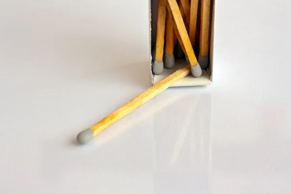 Cabeça cinza corresponde com caixa no fundo branco — Fotografia de Stock