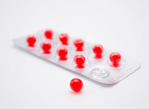 Красная круглая таблетка — стоковое фото