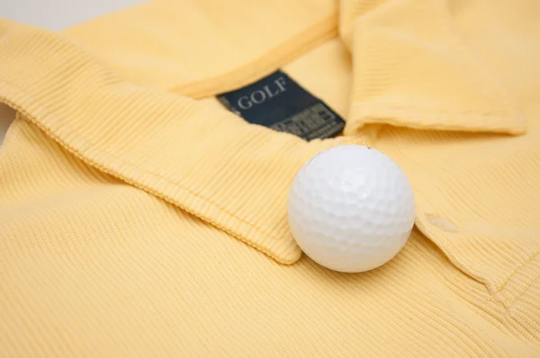 Мяч для гольфа и рубашка для поло — стоковое фото