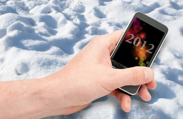 Смартфон в руке - Новый год 2012 — стоковое фото