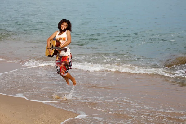 幸せな女の子ビーチでギターとジャンプ — ストック写真