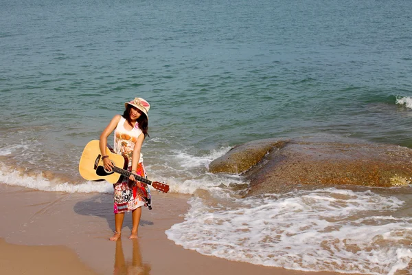 Bella giovane donna che suona la chitarra sulla spiaggia — Foto Stock