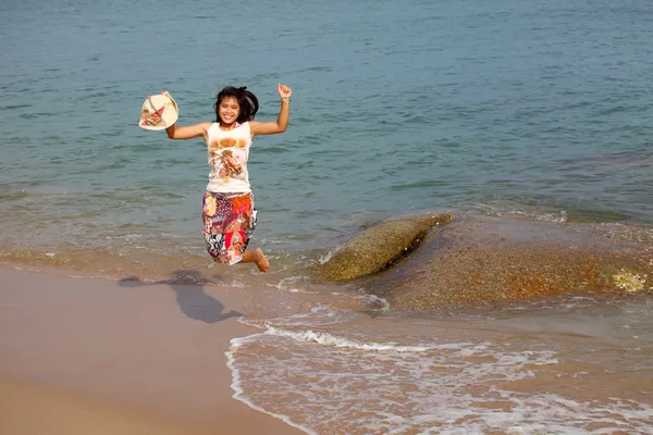 Gelukkig jonge vrouw springen op strand — Stockfoto