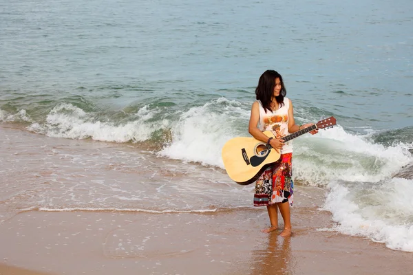 かなり若い女性のビーチでギターを弾く — ストック写真