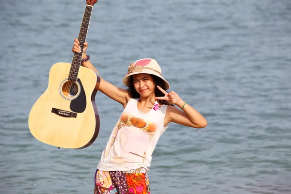 Hezká mladá žena s akustickou kytaru na pláži — Stock fotografie