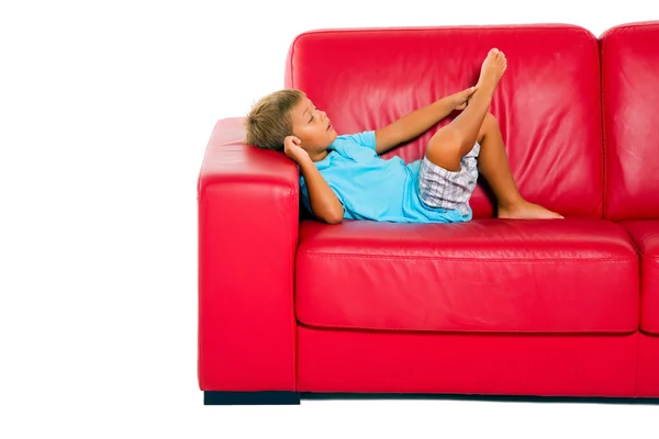 在红色沙发上的男孩 — 图库照片