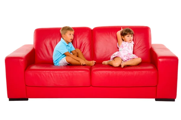 兄と妹の赤いソファで — ストック写真