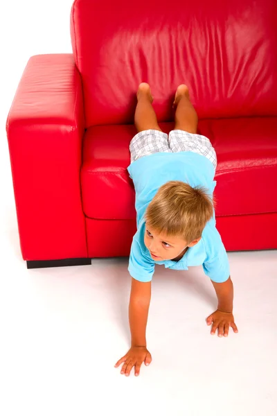 Pojke på röd soffa — Stock fotografie