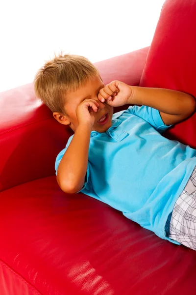 Boy on red sofa — Stok fotoğraf