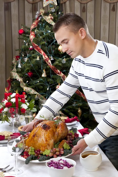 Hombre con pavo asado de Navidad adornado — Foto de Stock
