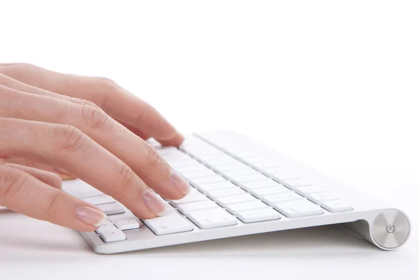Manos escribiendo en el teclado remoto del ordenador inalámbrico — Foto de Stock